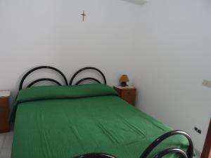 a bedroom with a green bed with a green comforter at Casa Orchidea in Lipari