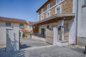 un edificio con una puerta y una valla delante en La maison d'Hana, en Saint-Bonnet-de-Valclérieux