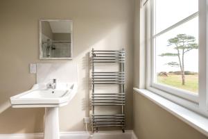 a bathroom with a sink and a mirror and a window at The Dower House in Sizewell +52 photos