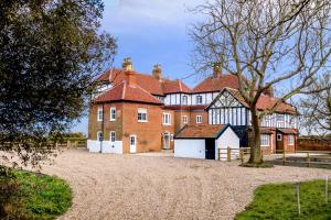 a large brick building with a tree in front of it at The Dower House in Sizewell