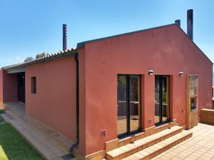 Casa roja con puertas de cristal y porche en Vistas al Sueve, en Colunga