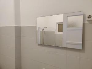 a mirror on the wall of a bathroom at Vasco Santana Guesthouse in Odivelas