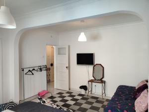 a living room with a tv and a checkered floor at Vasco Santana Guesthouse in Odivelas