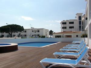 eine Reihe von Liegestühlen neben einem Pool in der Unterkunft Apartamentos Turisticos Monte da Vinha II in Albufeira