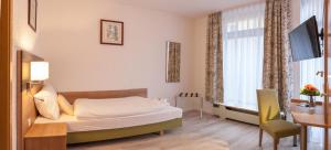 Pokój hotelowy z łóżkiem, biurkiem i oknem w obiekcie EulenNest w mieście Laubach