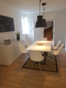 Brackenheim的住宿－Ferienwohnung，一间设有白色桌子和白色椅子的用餐室
