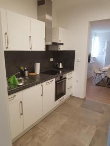 cocina con armarios blancos y fogones en Ferienwohnung en Brackenheim