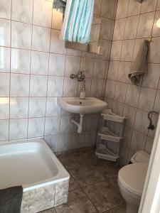 Rozogi的住宿－Gospodarstwo Agroturystyczne u Kubziniaka，浴室配有盥洗盆、卫生间和浴缸。