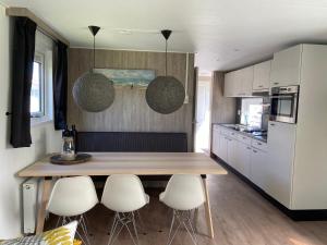 a kitchen with a wooden table and some white appliances at olmenduin 33 in Serooskerke