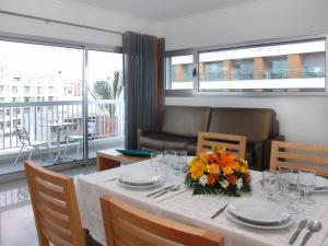 a dining room with a table with flowers on it at Apartamentos Turisticos Monte da Vinha II in Albufeira