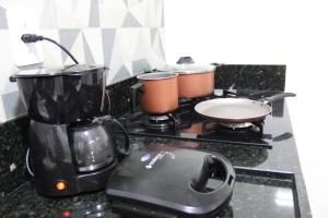 un fornello da cucina con due pentole e un frullatore di Ap novo a 90m da praia a Guarapari Altre 10 foto