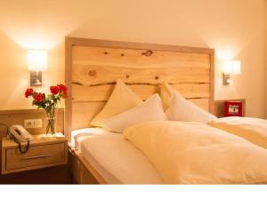 a bedroom with a bed with white pillows and a phone at Gästehaus Schusser an der Therme, Frühstück, Doppelzimmer und Ferienwohnung in Bad Kleinkirchheim +70 photos