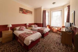 Bournemouth Sands Hotel tesisinde bir odada yatak veya yataklar