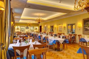 a restaurant with tables and chairs and a chandelier at Urlaubsresidenz Marstall und Kanzlei im Schlossensemble in Lübbenau