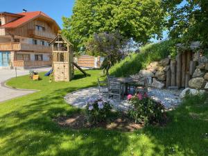 einen Garten mit einem Tisch und einem Spielplatz in der Unterkunft Wastlbauer in Mattsee