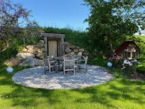 a table and chairs on a gravel patio in a garden at Wastlbauer in Mattsee