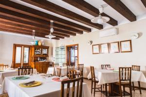a dining room with white tables and chairs and wooden ceilings at Locanda Solagna in Quero