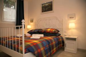 1 dormitorio con 1 cama con manta a rayas en Giripaso Apartment, en Florencia