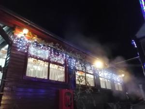 una casa cubierta de luces de Navidad por la noche en Casa Bazna en Bazna
