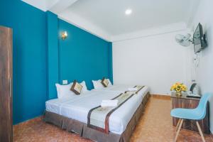 a bedroom with a large bed with blue walls at Khải Hoàng 2 in Da Lat