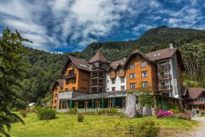 a large building in front of a mountain at Hotel Natura in Peulla