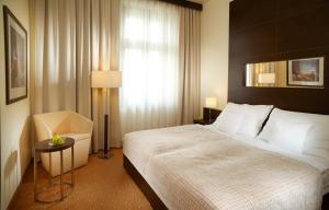 a hotel room with two beds and a lamp at Clarion Hotel Prague City in Prague