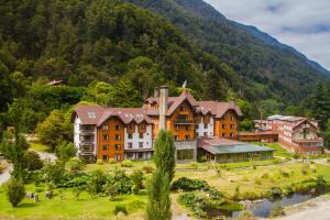 a hotel in a valley with a mountain at Hotel Natura in Peulla