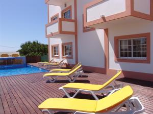 
a row of chairs sitting on top of a patio at Apartamentos Monte da Vinha I in Albufeira
