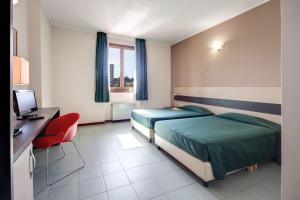 a hotel room with two beds and a desk at Hotel Alba Roma in Rome