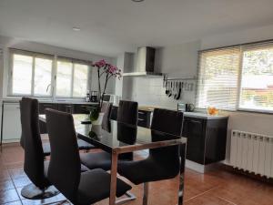 une cuisine avec une table à manger et des chaises noires dans l'établissement Apartamento rural NÍVALIS, à Nívar