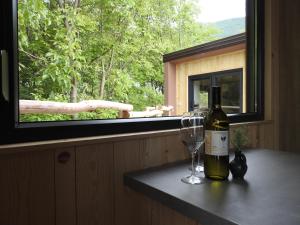 Small holiday houses في آيدوشتشينا: زجاجة من النبيذ وكأس من النبيذ على منضدة