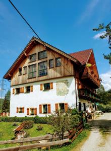 Una gran casa de madera con un blanco en Mühlnerhof Familie Gruber, en Aich