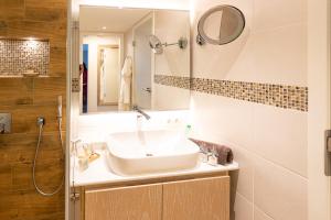 un baño con lavabo y espejo en Maurers Schlierseetraum 1 hochwertige Erdgeschosswohnung mit allen Raffinessen erfreut sich auch Urlauber idealerweise für Paar mit Kindern geeignet und Vierbeiner Dank des tollen Zauns auf der Terrasse stylisch und edel von der Ausstattung mit 64 qm, en Schliersee 40 fotos más