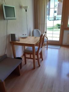 レンクにあるHotel Garni Alpinaのテレビ付きの客室で、木製のテーブルと椅子が備わります。