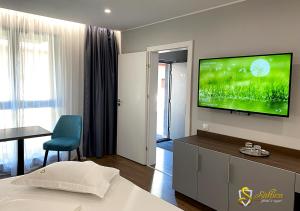 a hotel room with a bed and a flat screen tv at Hotel Saftica in Săftica