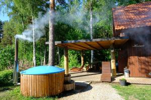 Kallaste Talu- Turismitalu & Holiday Resort في Padise: جناح خشبي يخرج منه الدخان