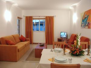 a living room with a couch and a table at Apartamentos Monte da Vinha I in Albufeira