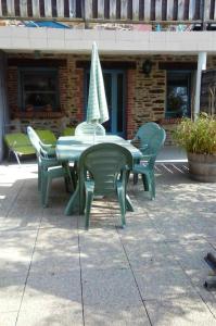 un tavolo e sedie con ombrellone su un patio di Appartement d'une chambre avec jardin clos et wifi a Hirel a Hirel