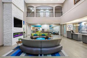 a living room with a large couch in a lobby at La Quinta by Wyndham Sulphur Springs in Sulphur Springs