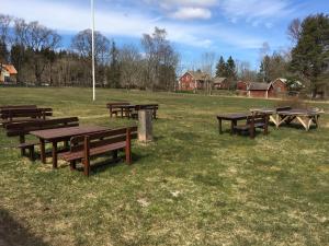 a group of picnic tables in a field at Kronobergshed vandrarhem och kursgård in Moheda