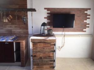 een woonkamer met een televisie, een tafel en een bureau bij il tramonto in Porto Cesareo