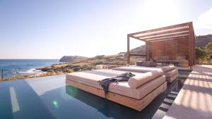 a bed sitting on top of a pool next to the ocean at Nuez Villas in Mochlos