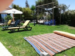 eine Decke auf dem Gras mit zwei Stühlen und einem Regenschirm in der Unterkunft Quinta Sao Martinho in Reguengo Grande