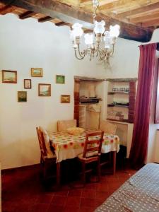 una sala da pranzo con tavolo, sedie e lampadario pendente di Tufoletto a Pitigliano