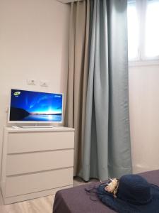 un televisor sentado en un tocador en un dormitorio en Rivabella Suite Apartments, en Rímini