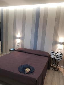 1 dormitorio con 1 cama con sombrero en Rivabella Suite Apartments, en Rímini