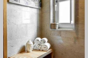 baño con banco con toallas y ventana en Charming Duplex at Alfama, en Lisboa 22 fotos más