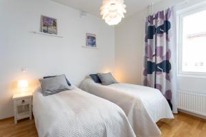 two beds in a room with a window and a chandelier at Tuomas´ luxurious suites, Kelo in Rovaniemi