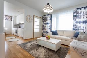 a living room with a white couch and a table at Tuomas´ luxurious suites, Kelo in Rovaniemi