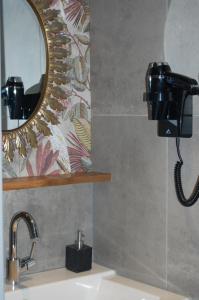 a bathroom sink with a mirror and a hair dryer at pipowagen/paardentram in Dreumel